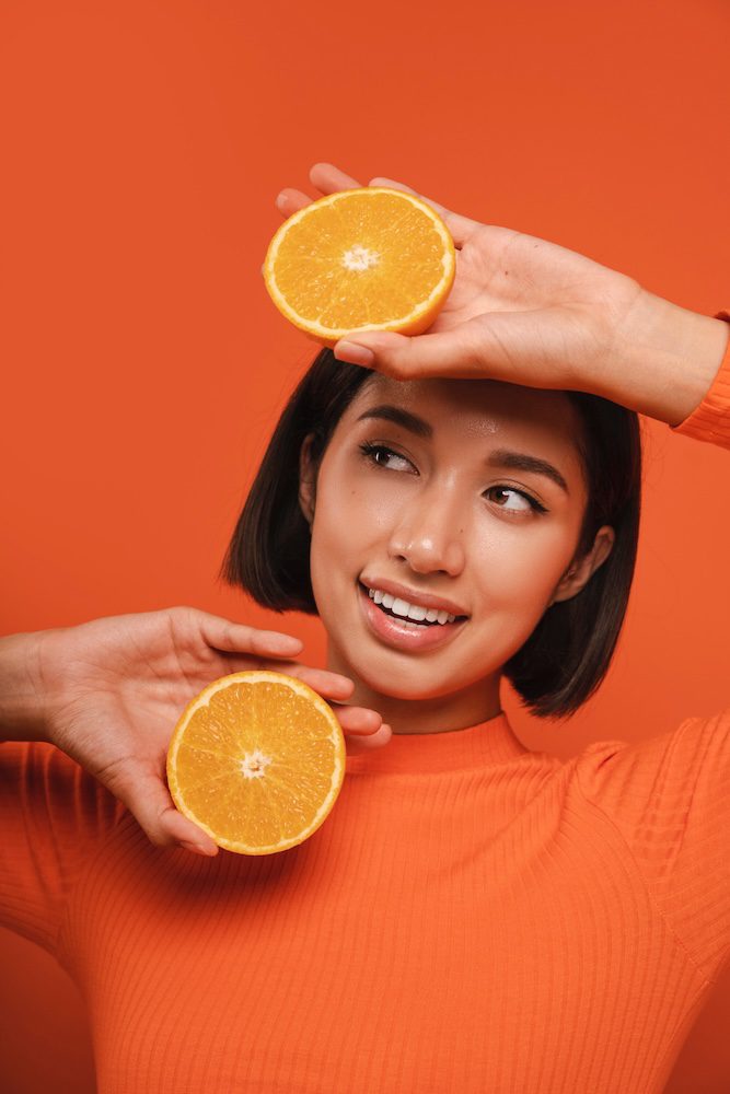 Vitamin-C Beauty – Frau hält Orangenhälften, frische und strahlende Haut | MY AESTHETICS Nürnberg