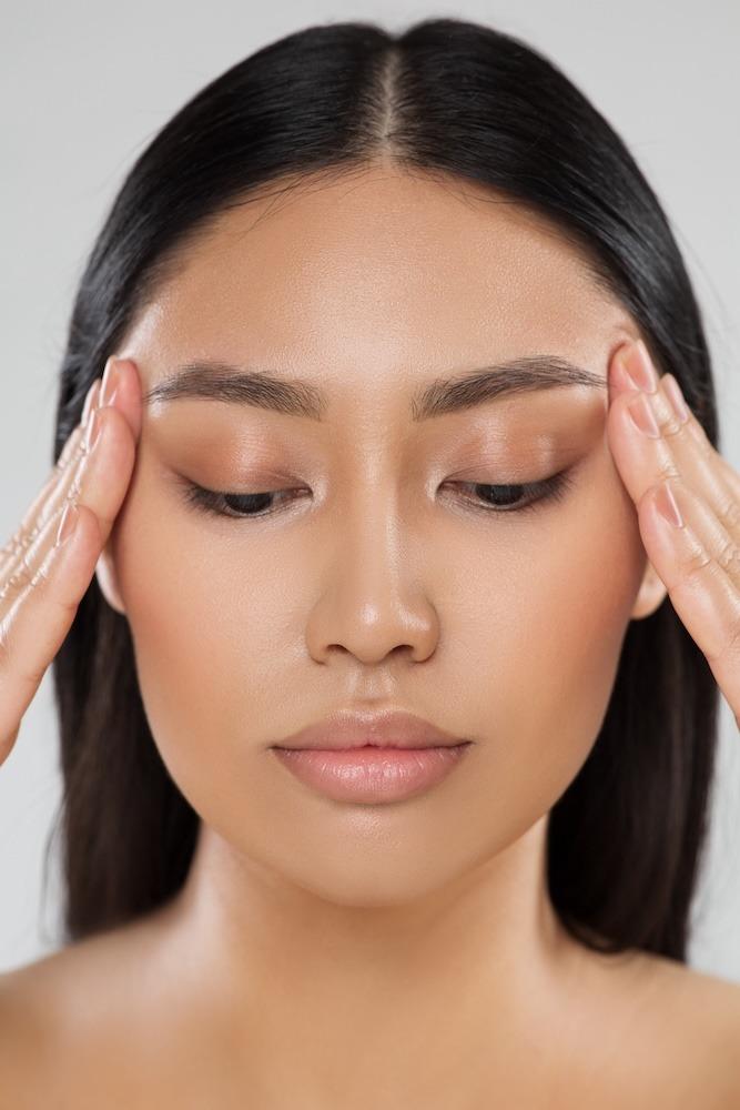 Beauty Woman Closeup Face Lift Massage. Beautiful Asian Model Portrait with Natural Make up. Women Facial Dermal Filler. Eyes Care Cosmetology and Plastic Surgery